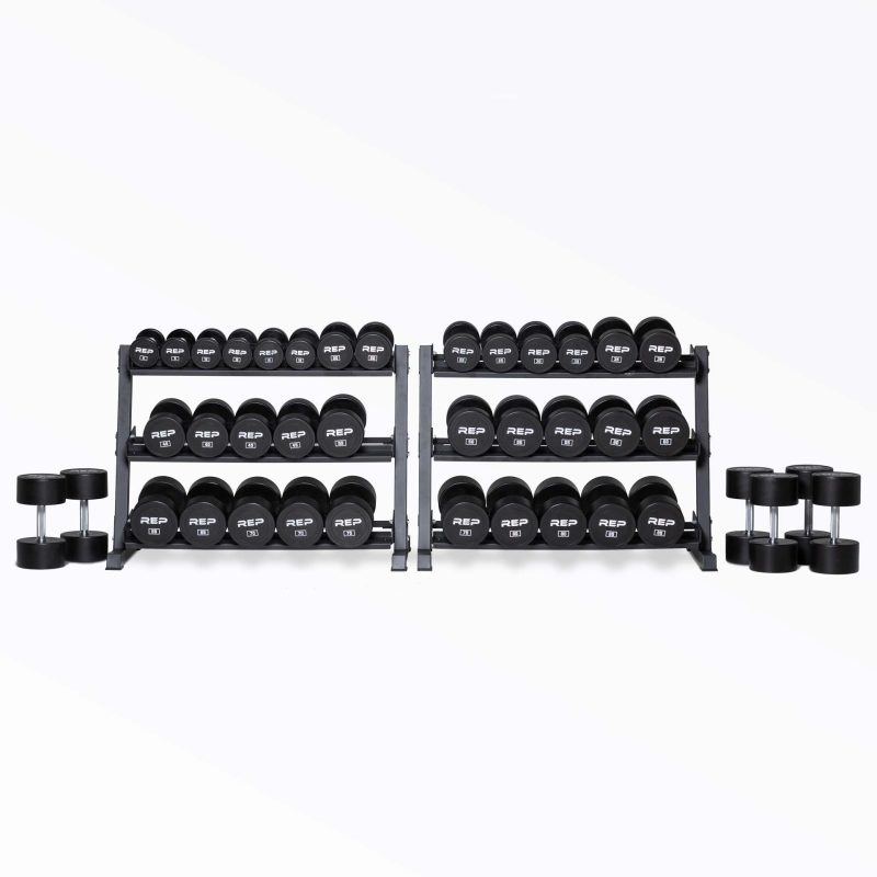 5-100lb Urethane Dumbbell Set stored on two REP Dumbbell Racks with the 90, 95, and 100lb pairs being stored on the ground next to the racks.